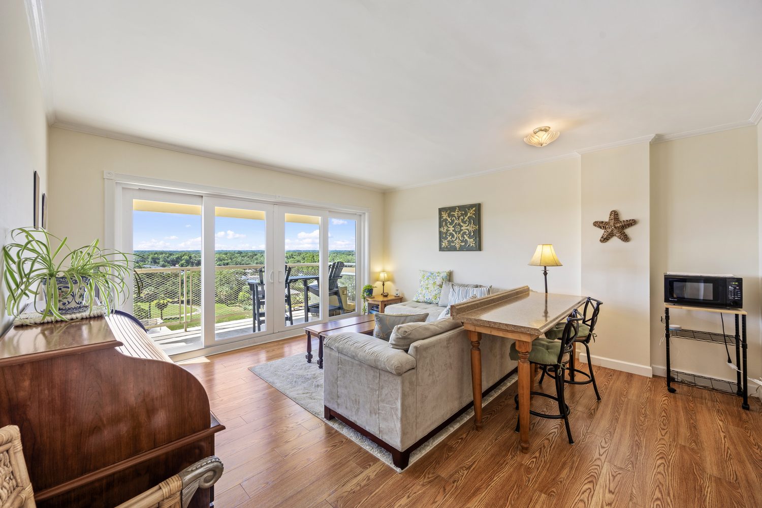 Living room of Unit 803 with sliding glass doors opening to a balcony over Pensacola Bay